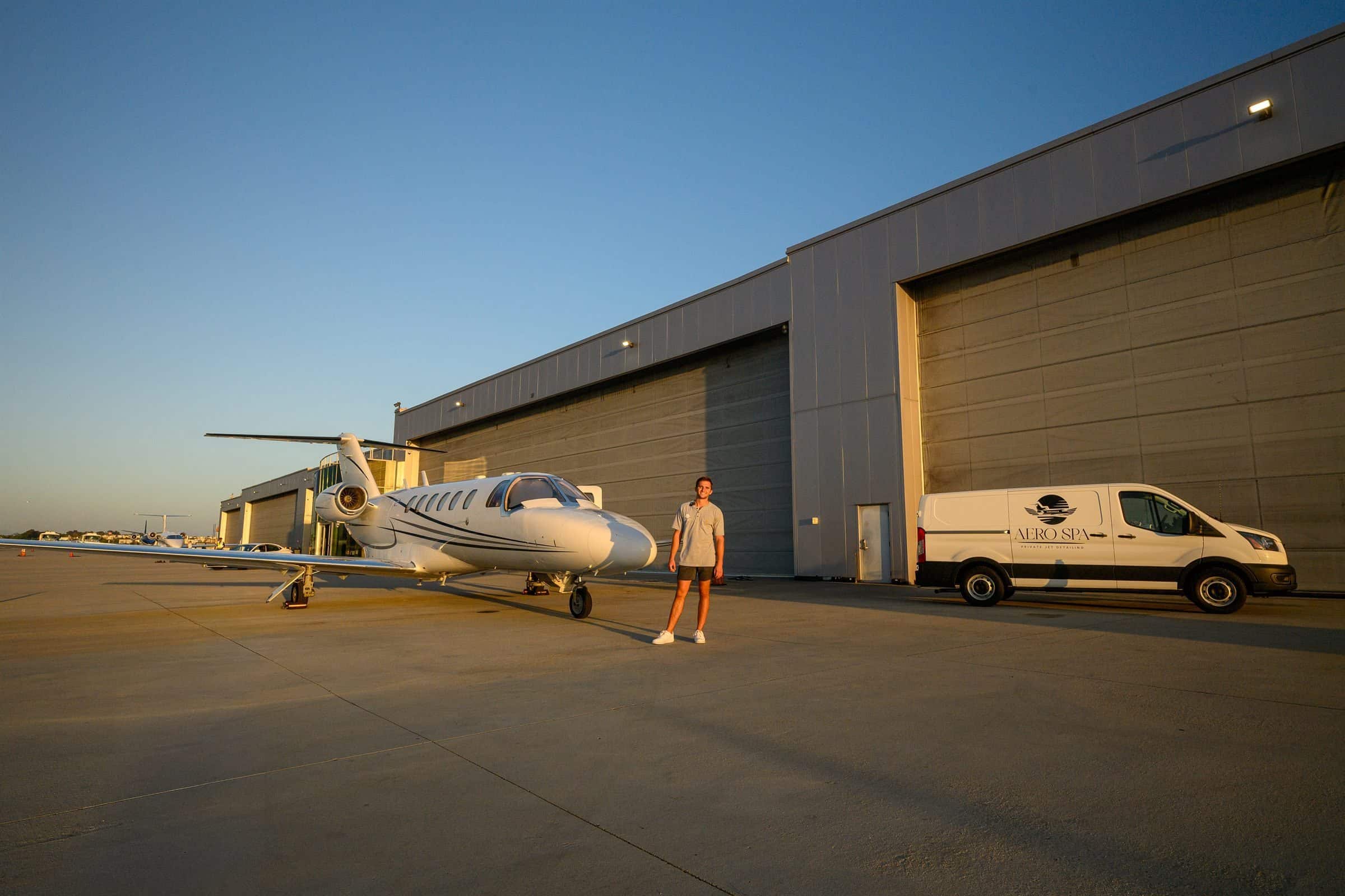 Jack Kennedy stands between a freshly detailed Citation jet and the Aero Spa van outside a hangar at sunset